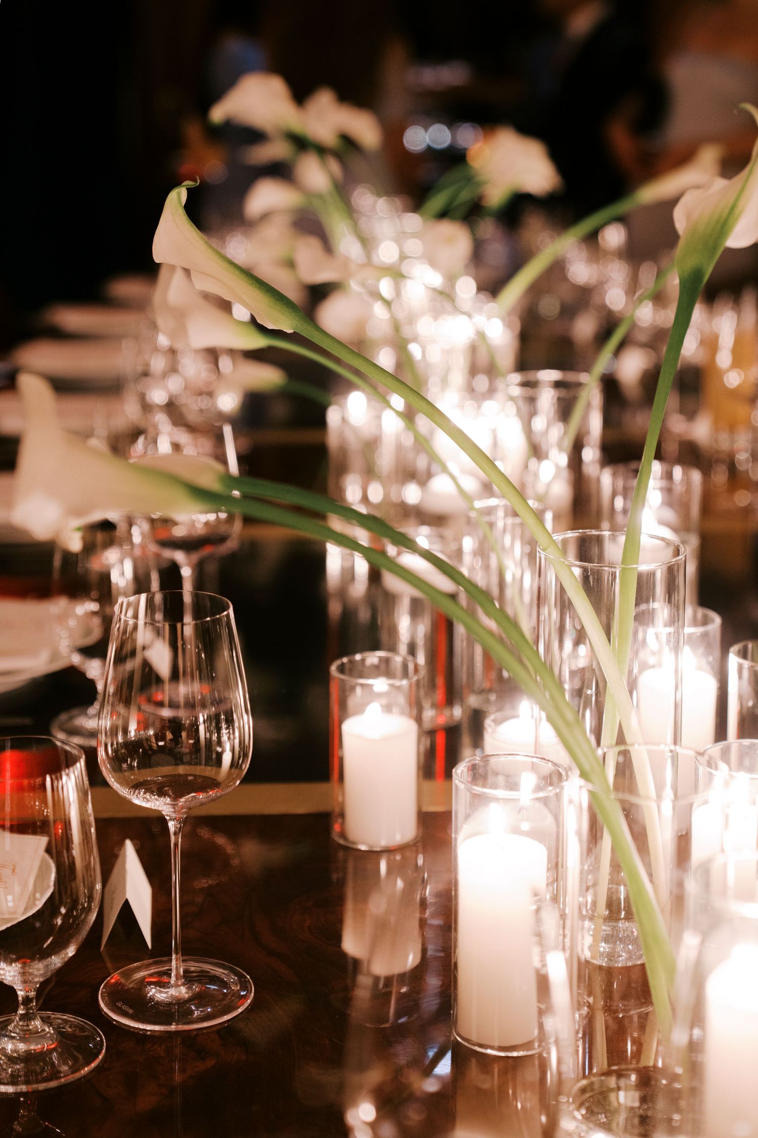Elegant table settings with glowing candles and wine glasses create an intimate dining atmosphere at dusk.
