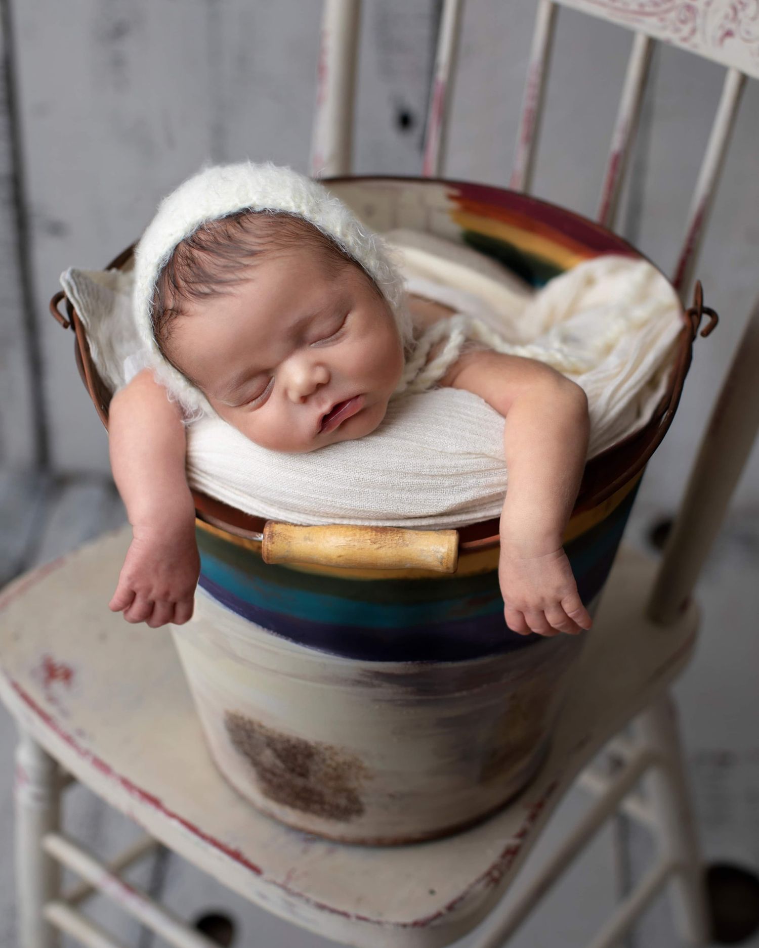A sleeping baby rests in a ceramic pottery bowl in a series of artistic photographs. Elizabeth Lang Photography Surrey