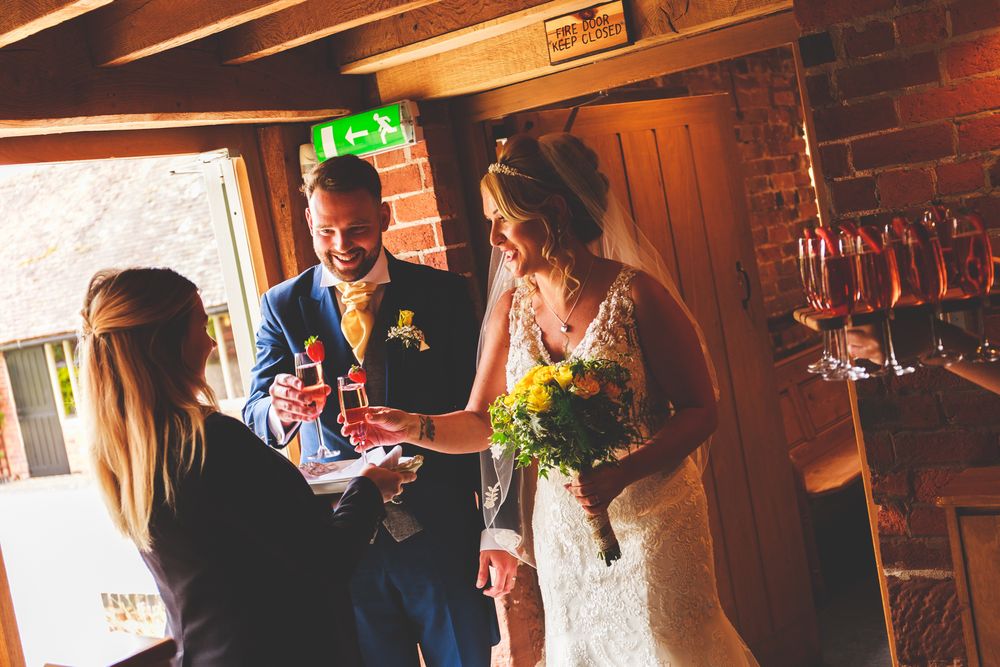 A celebration moment in a rustic venue with exposed brick walls and wooden beams.