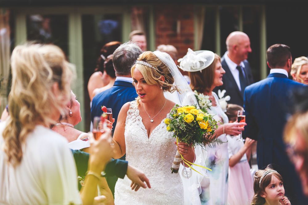 Wedding celebration with guests dancing and celebrating outdoors.