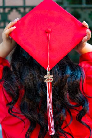 A bright red graduation cap with white tassel shown in a sequence of close-up shots against dark hair.