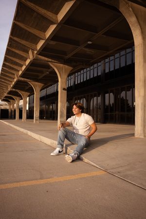 A sequence of five photos showing a person lying down in a parking garage at sunset with dramatic lighting.