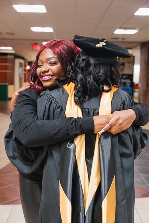 Four candid photos show graduates in black caps and gowns with gold stoles embracing in celebration at commencement.
