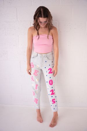 Pink and white painted jeans shown from different angles featuring playful number designs and patterns.