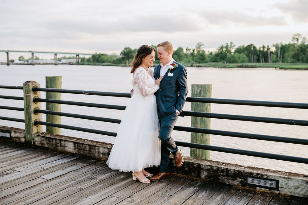 A romantic sequence of wedding photos showing a couple sharing intimate moments on a wooden dock overlooking the water.
