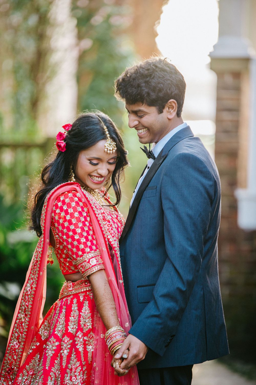 A couple in formal attire share intimate moments during their wedding photoshoot in an outdoor setting.