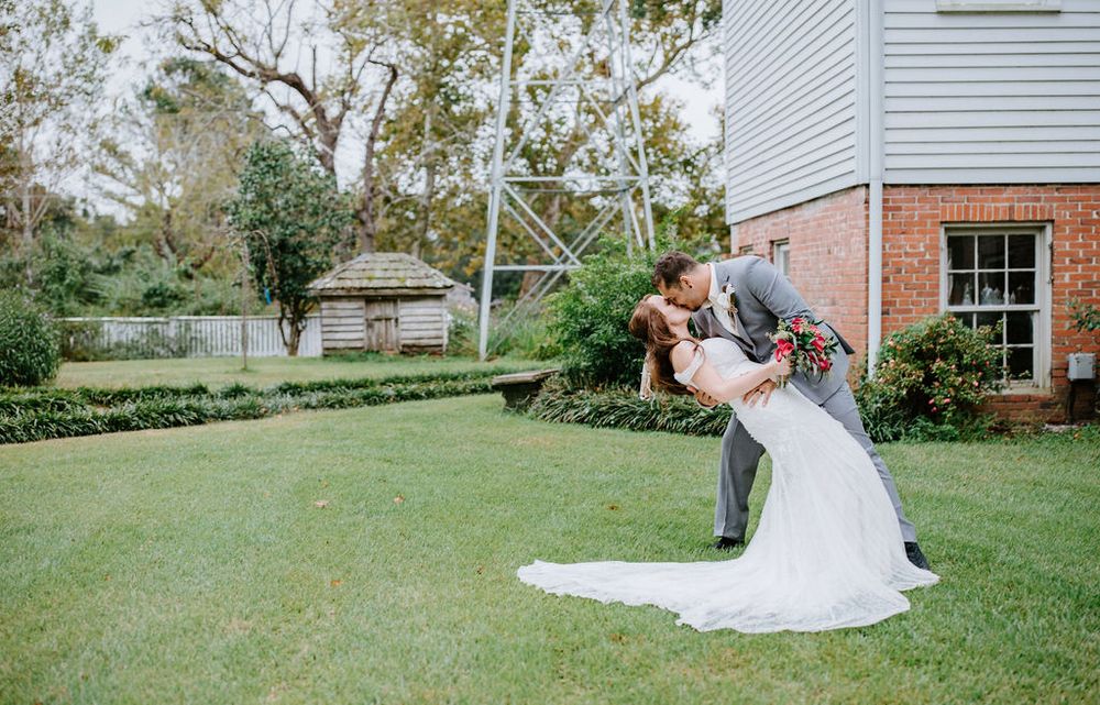 A couple dances and twirls together on a sunny lawn during a romantic outdoor celebration.