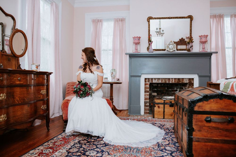 A series of vintage wooden dressers and furniture pieces arranged in an elegant room with soft pink walls.