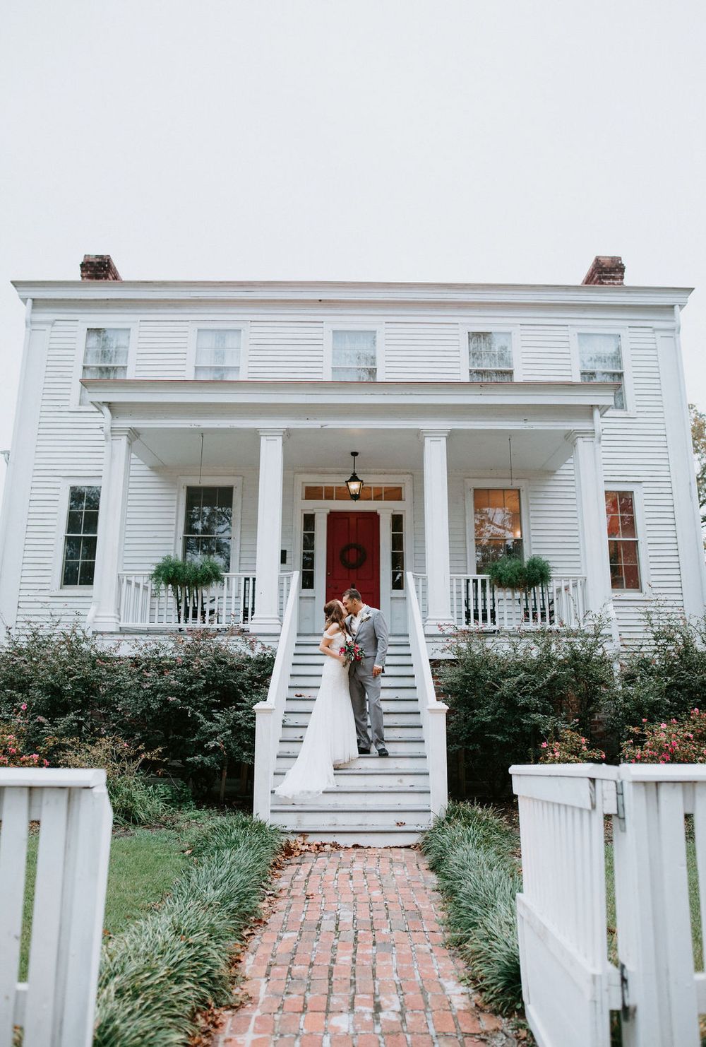 A white colonial style house with a front porch and brick walkway shown from three different angles.