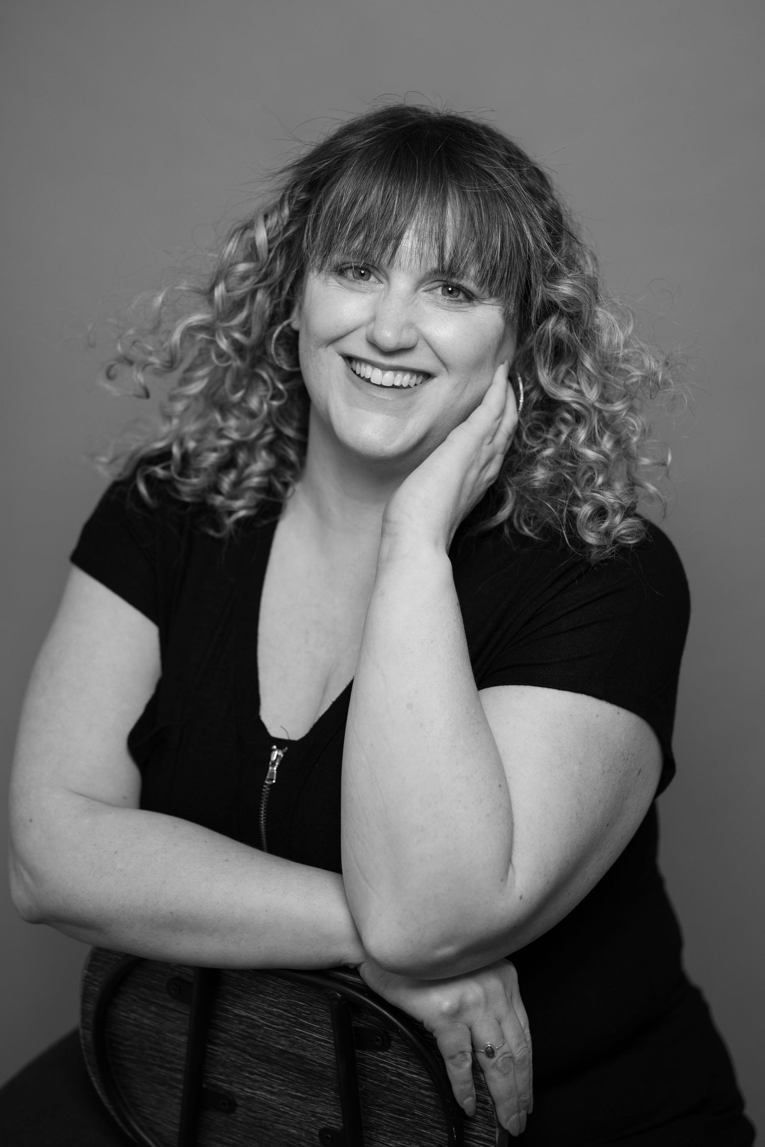 Black and white portrait series showing a woman in dark clothing making expressive poses against a simple background.