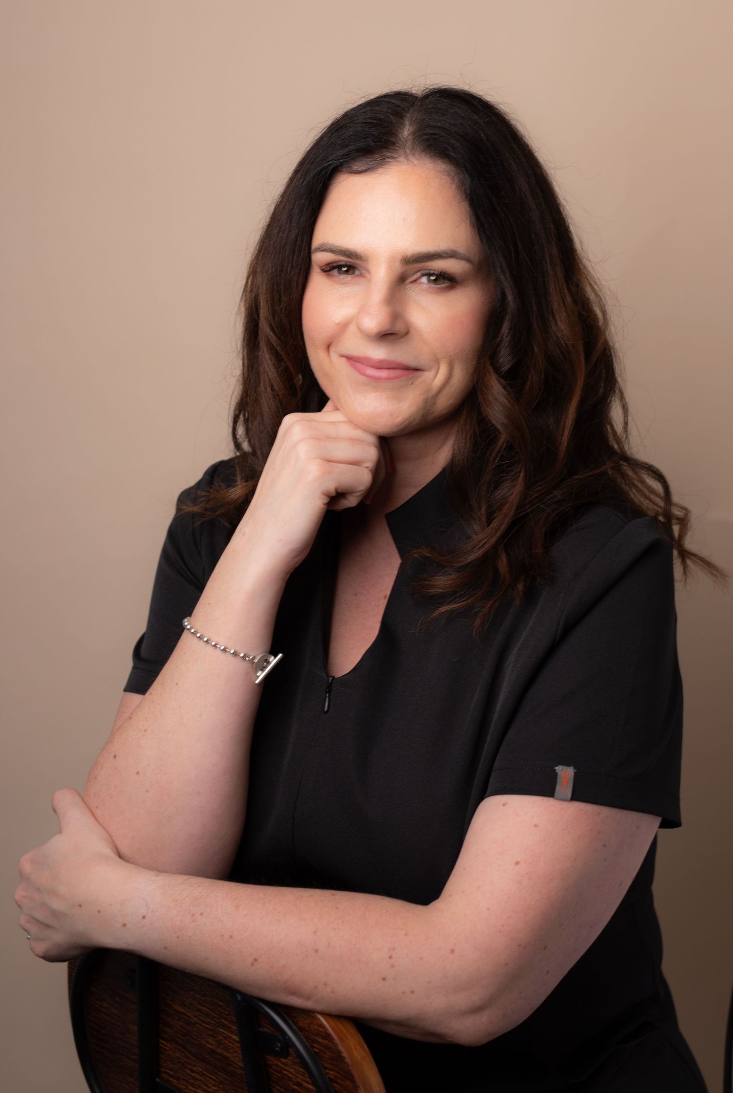 Professional headshot series showing a person in black attire against a neutral backdrop with varying poses and expressions.