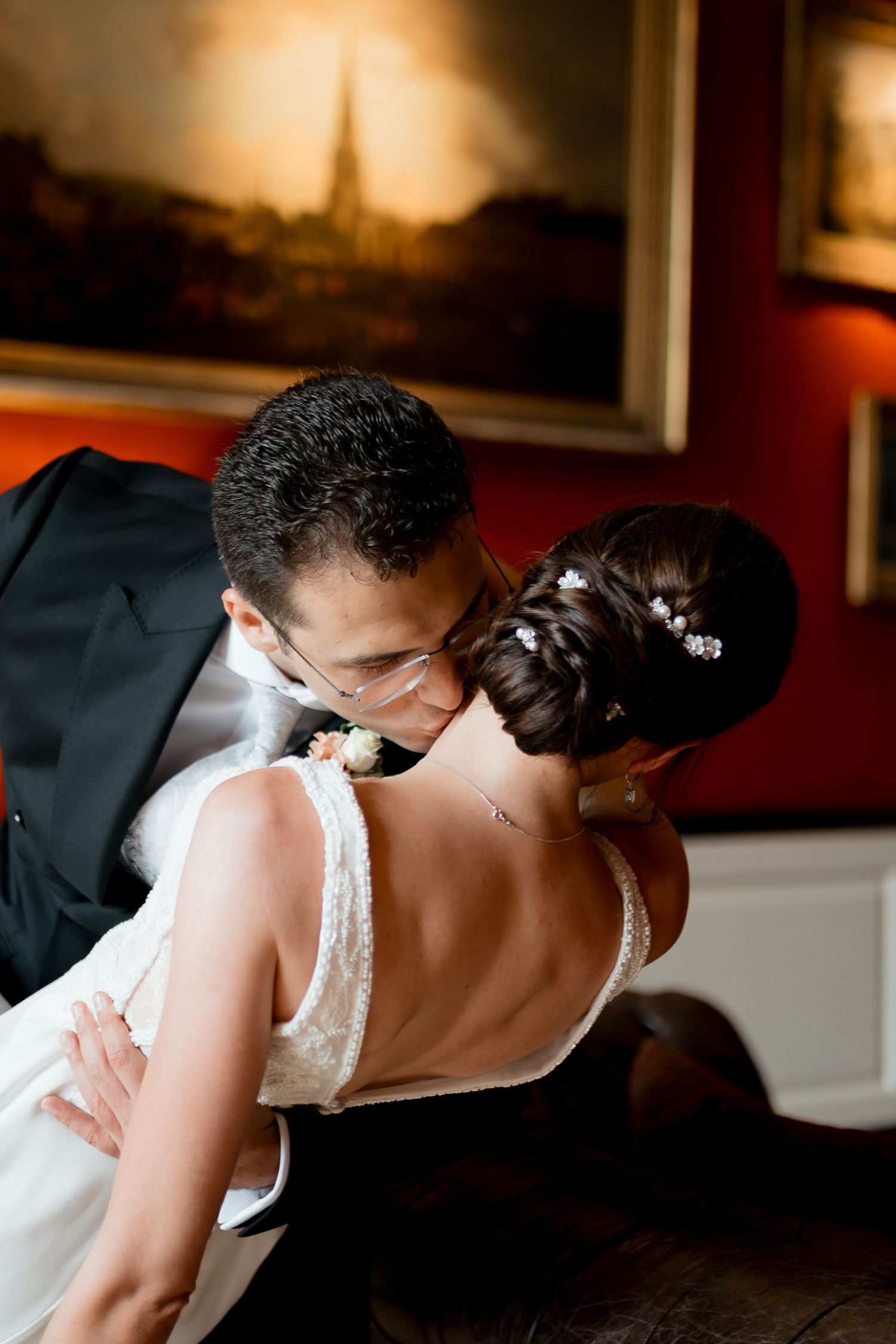 A romantic couple shares tender moments in a garden setting wearing white attire.