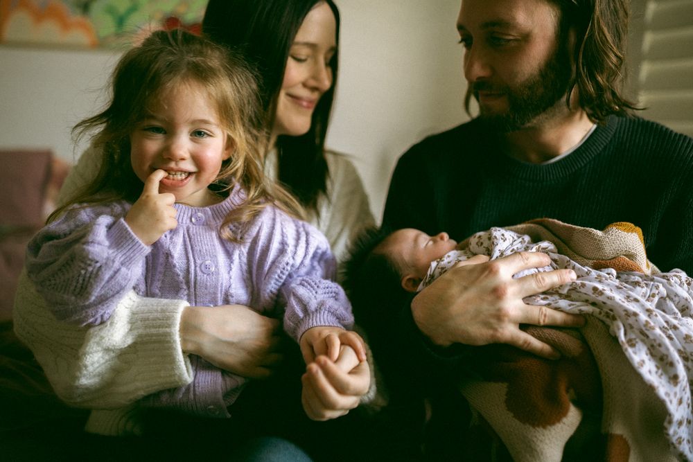 A joyful family moment captured in warm lighting as they spend time together with a baby.