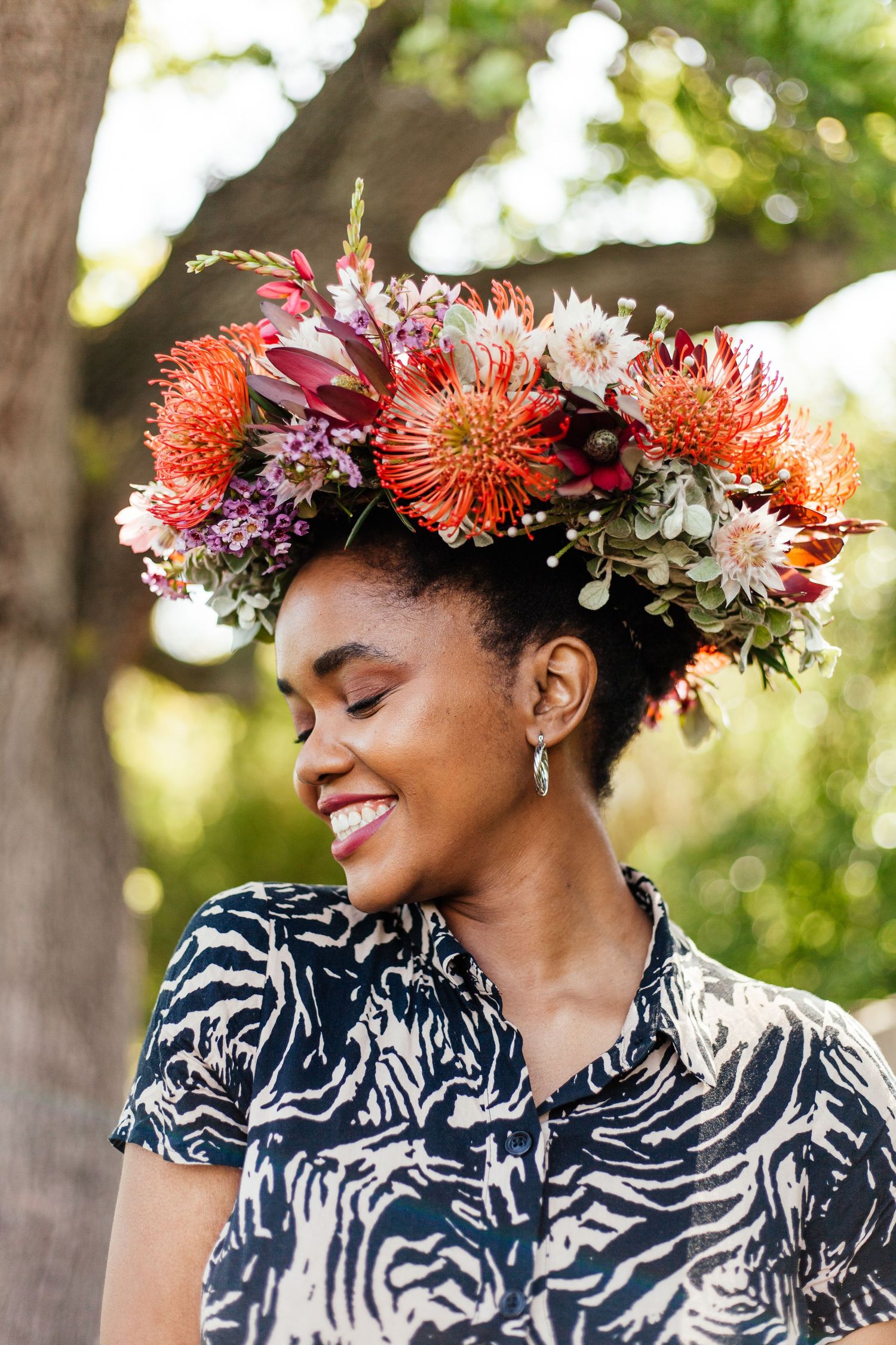 Vibrant floral crown with coral and purple blooms adorns against navy patterned fabric.