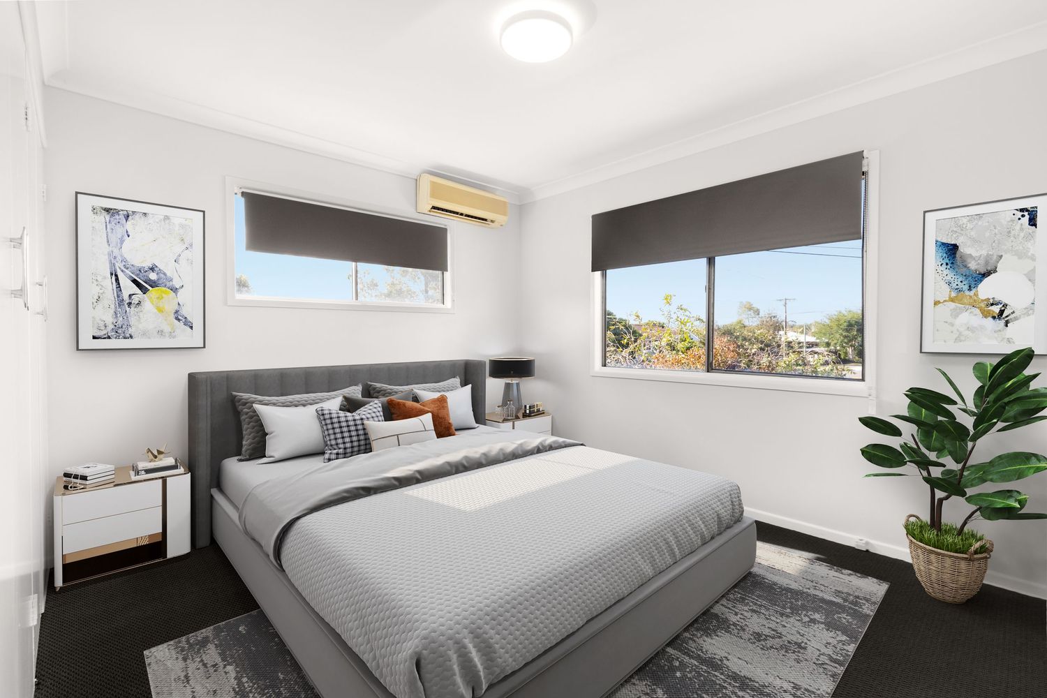 Modern bedroom with grey upholstered bed, split-system AC, roller blinds, and colorful artwork on white walls.