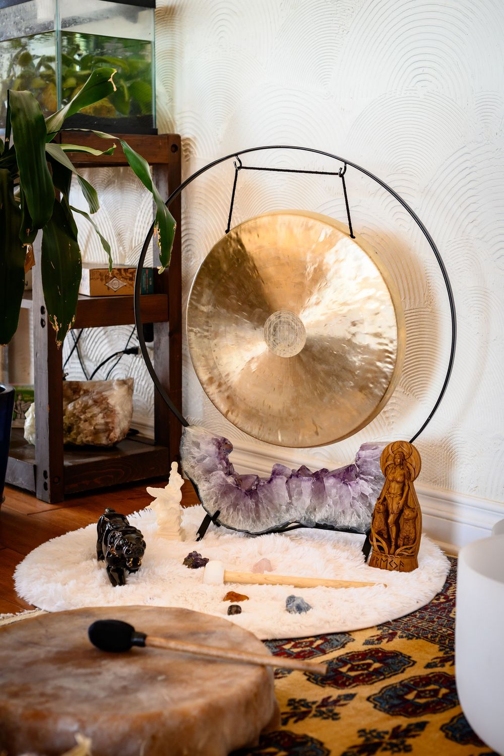 A decorative gong displayed on a stand with crystals and natural elements on a textured surface. Branding photography Las Vegas