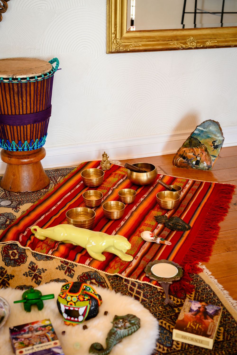 Tibetan singing bowls and meditation tools displayed  with a wooden djembe drum and decorative items. Branding photography Las Vegas