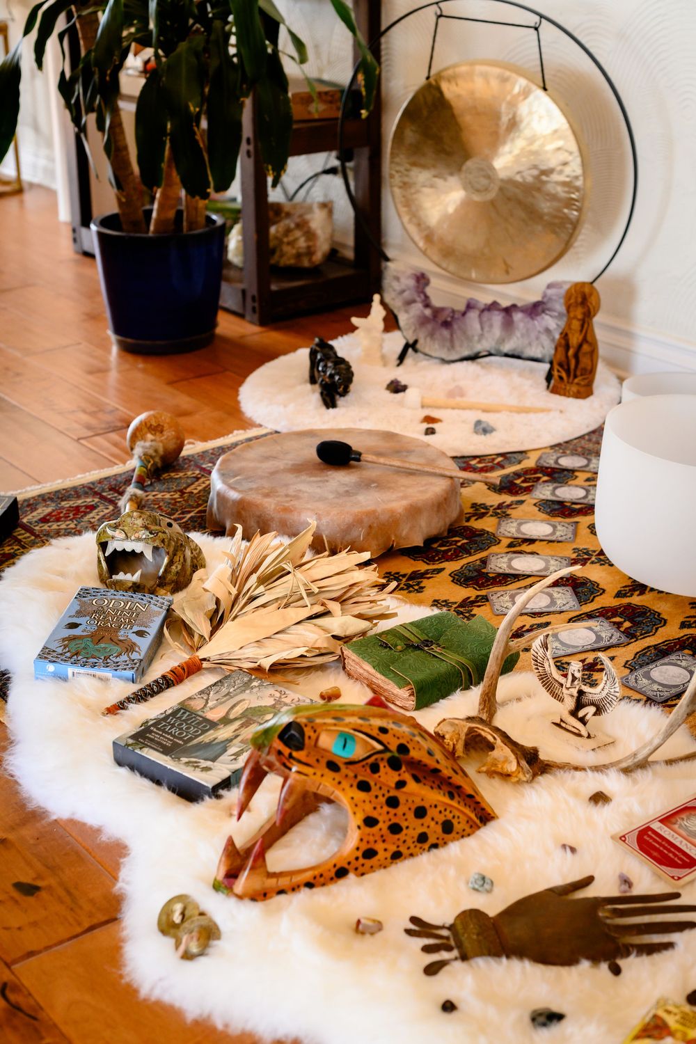 A craft table displays various creative materials including feathers, fabrics, and decorative items spread across a wooden surface.