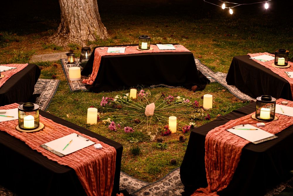 Rustic outdoor dining setup with lanterns and burgundy tablecloths on multiple tables at dusk. Branding photography Las Vegas
