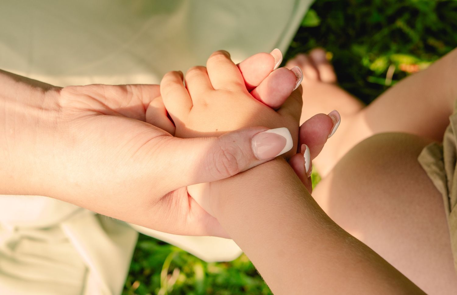 A parent and child share a joyful moment playing together outdoors during golden hour sunset.