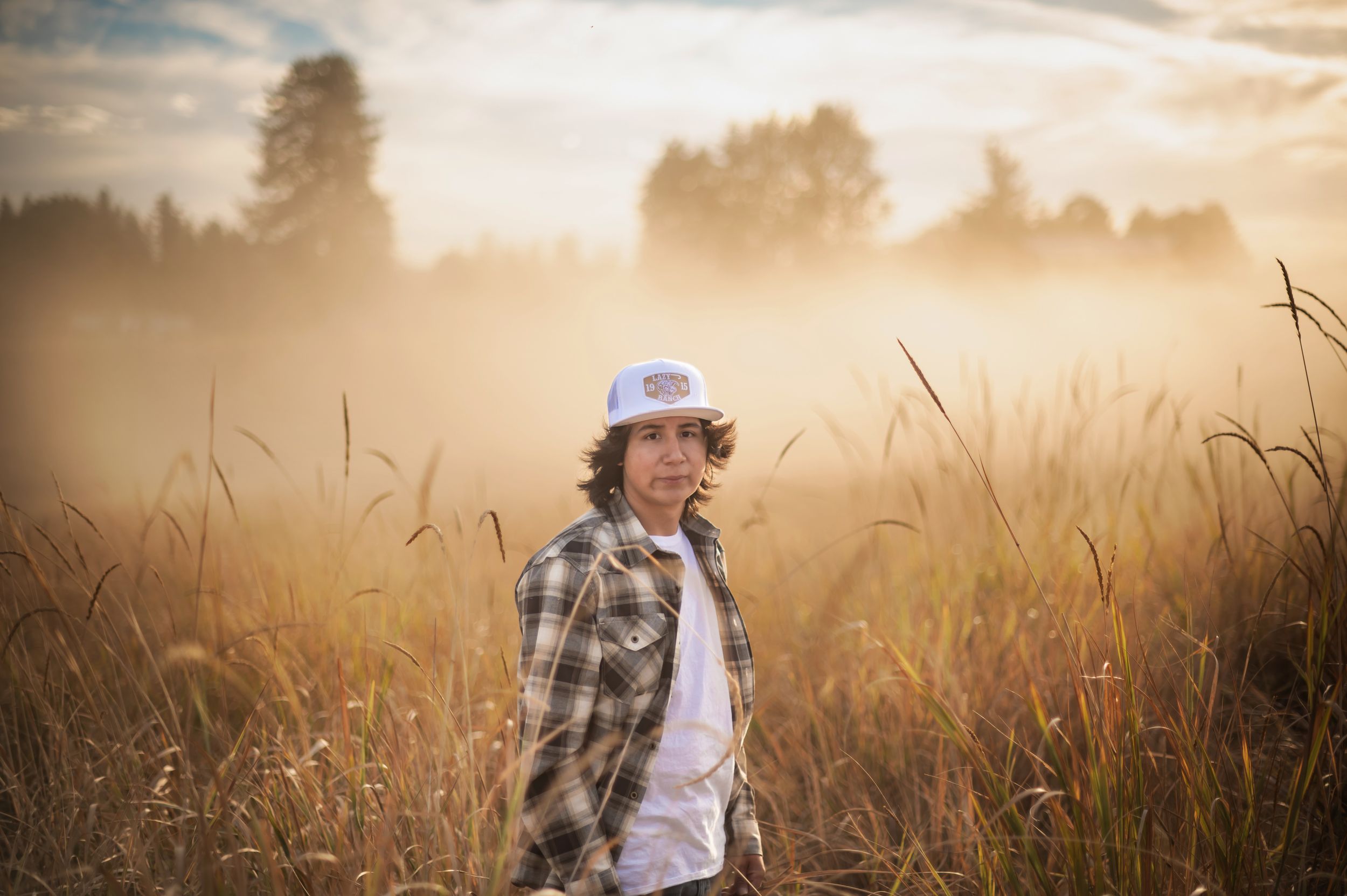 A senior portrait taken at sunset in a field at Feryn Conservation area in Mead Washington.