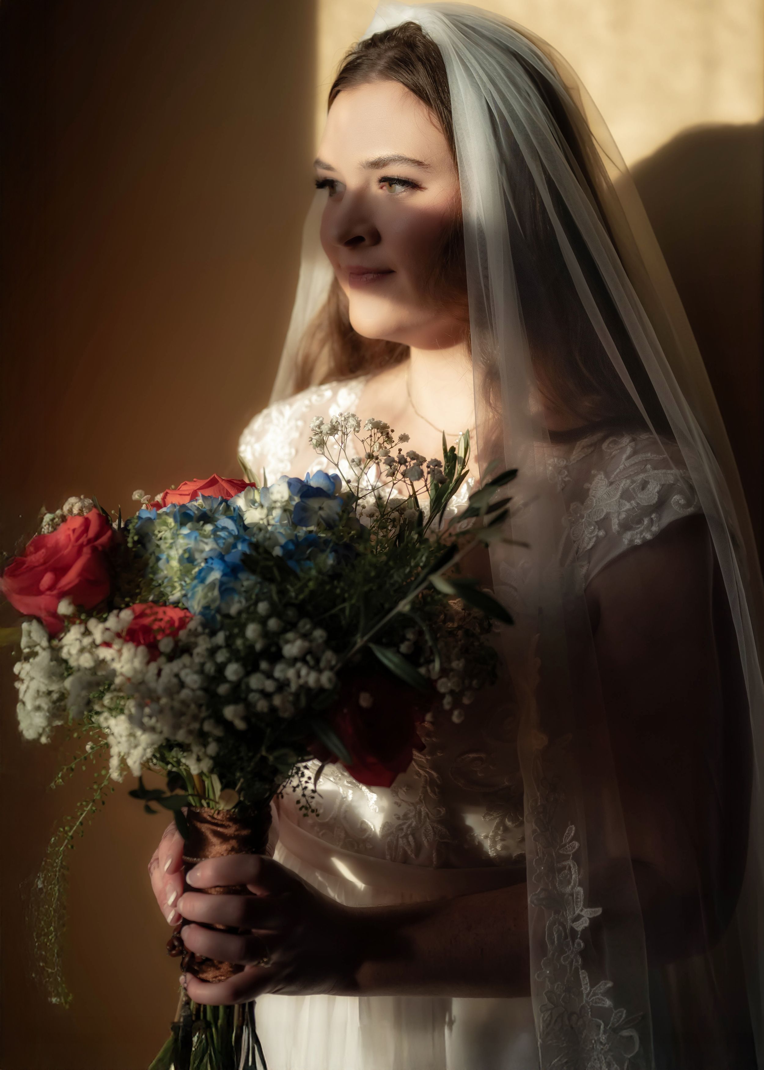 A dreamy wedding portrait of a woman in a wedding dress and veil with flowers at the Roberts Mansion and Inn in Spokane Washington.