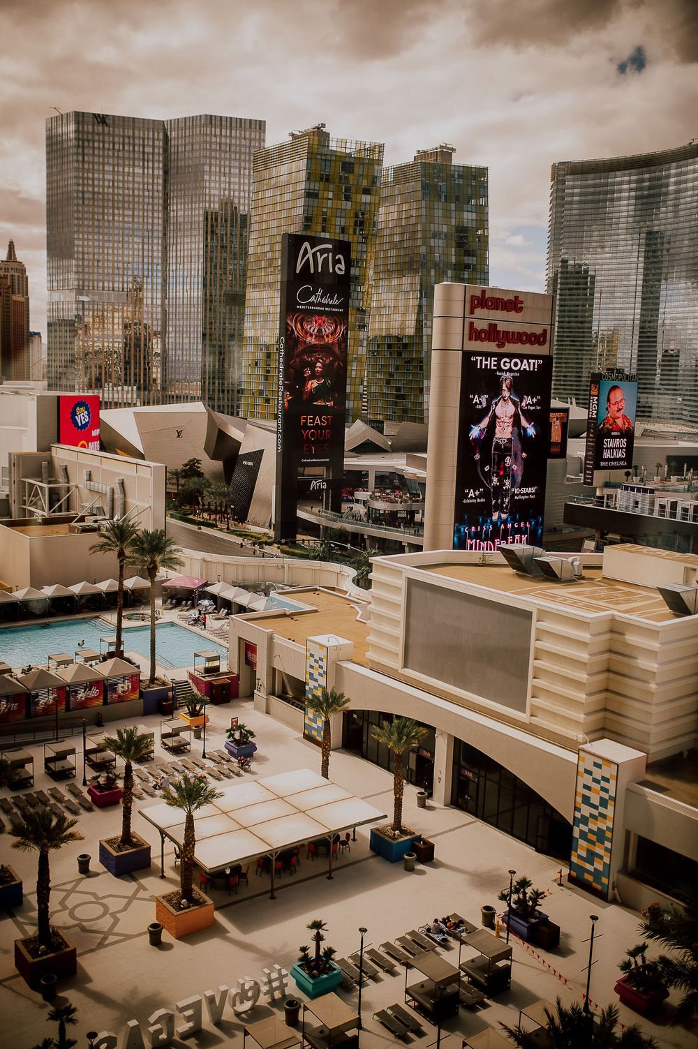 Panoramic view of an urban plaza with digital billboards and modern architecture in a city setting.