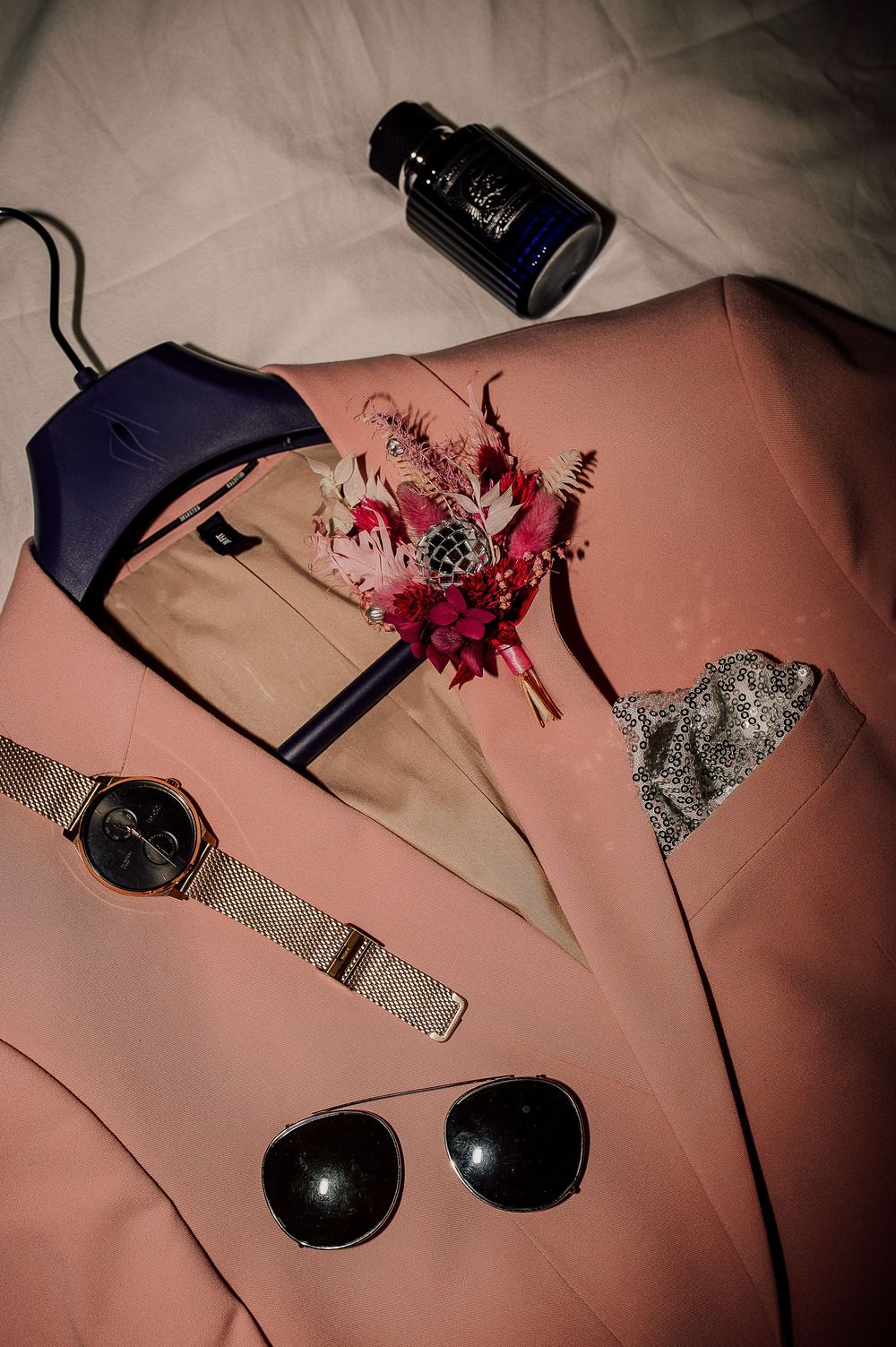 A sequence of pink floral arrangements and decorative accessories laid out on a pink surface in a progressive composition.