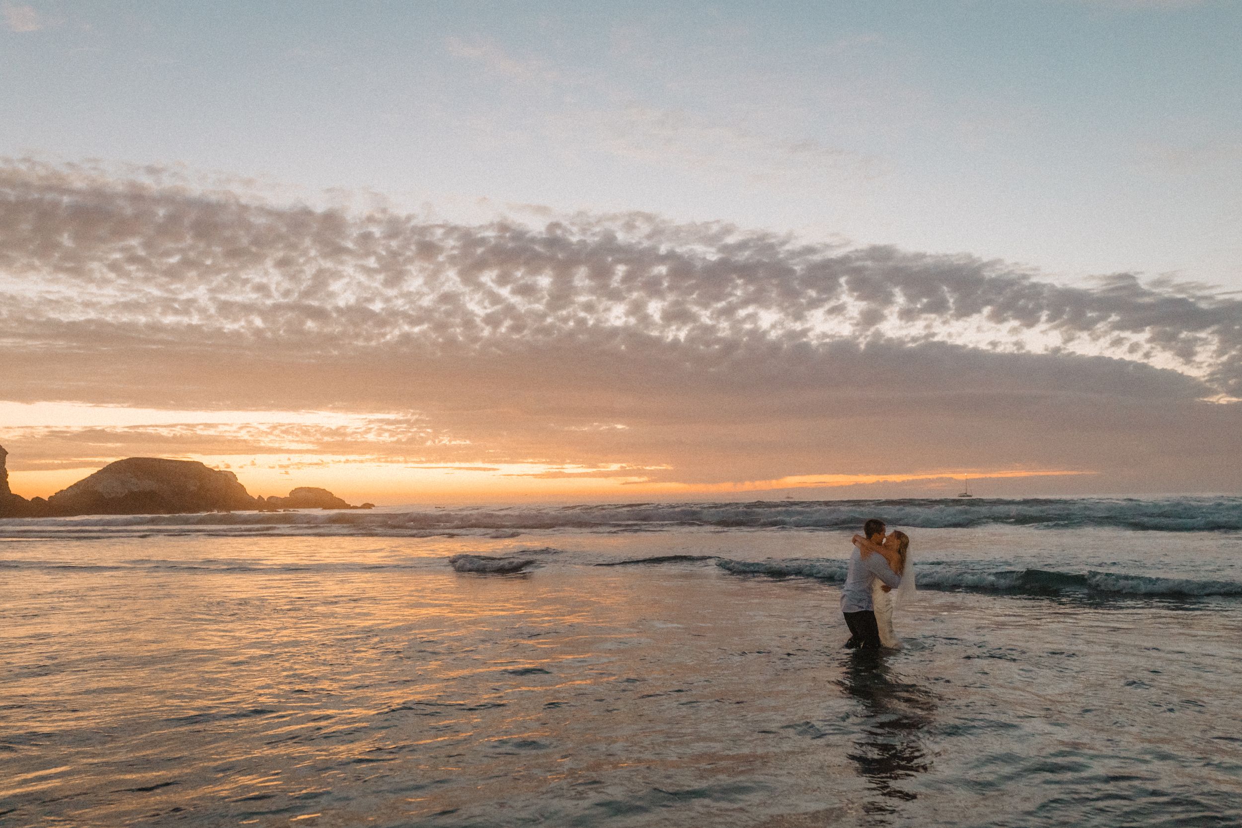 bride and groom photos in the water at the beach