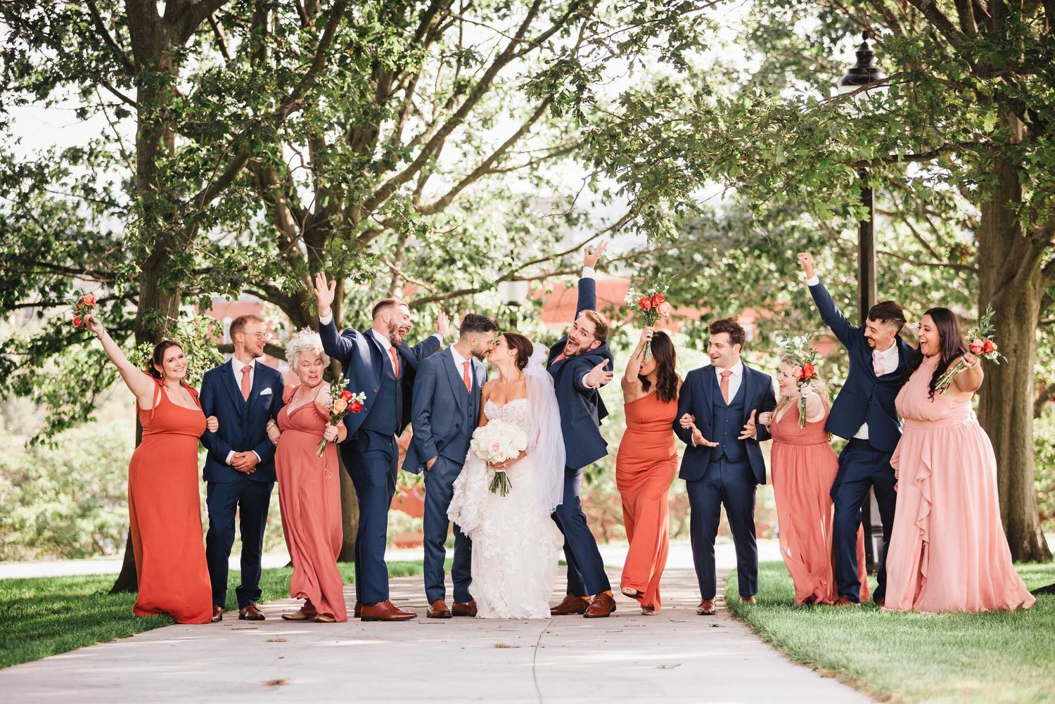 Bride and groom celebrating with bridal party during wedding portraits at Dorchester Heights in Boston