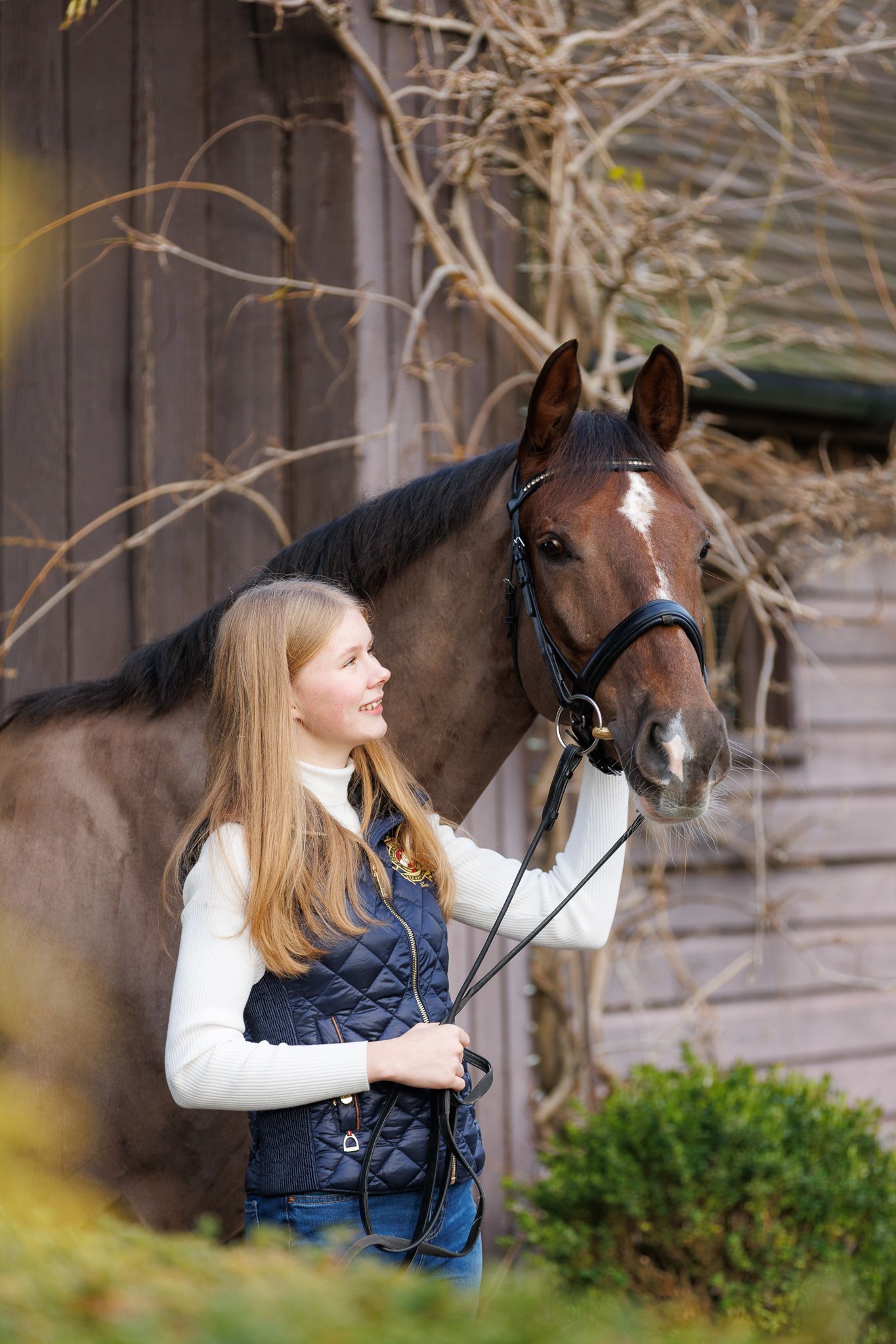 A series of photos showing a person with red hair interacting with a dark horse in a soft-focus outdoor setting.