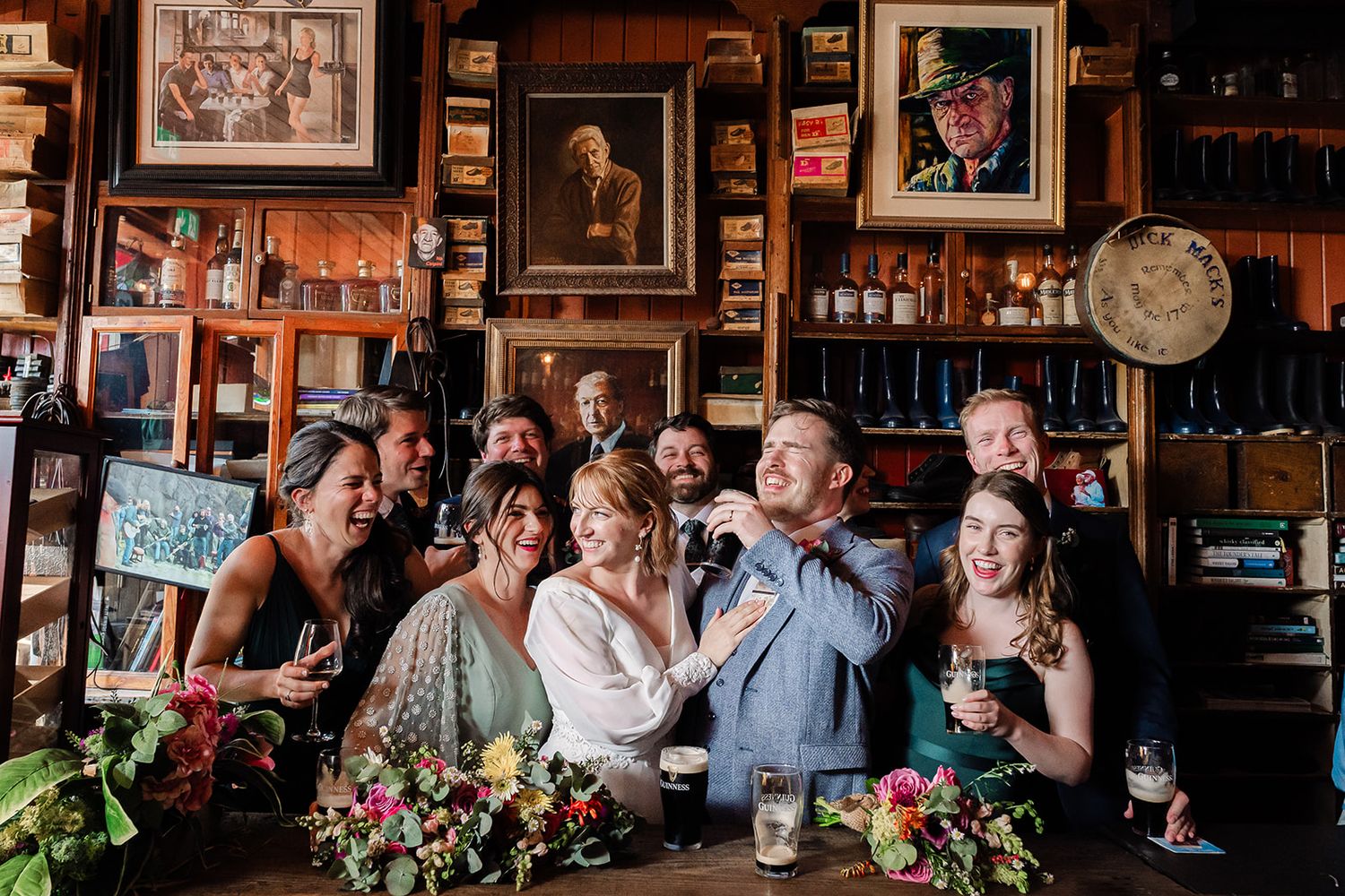 Wedding guests raise glasses in celebration at a rustic Irish pub. Dick Mack's Wedding Photos by Sarah Kate Photography