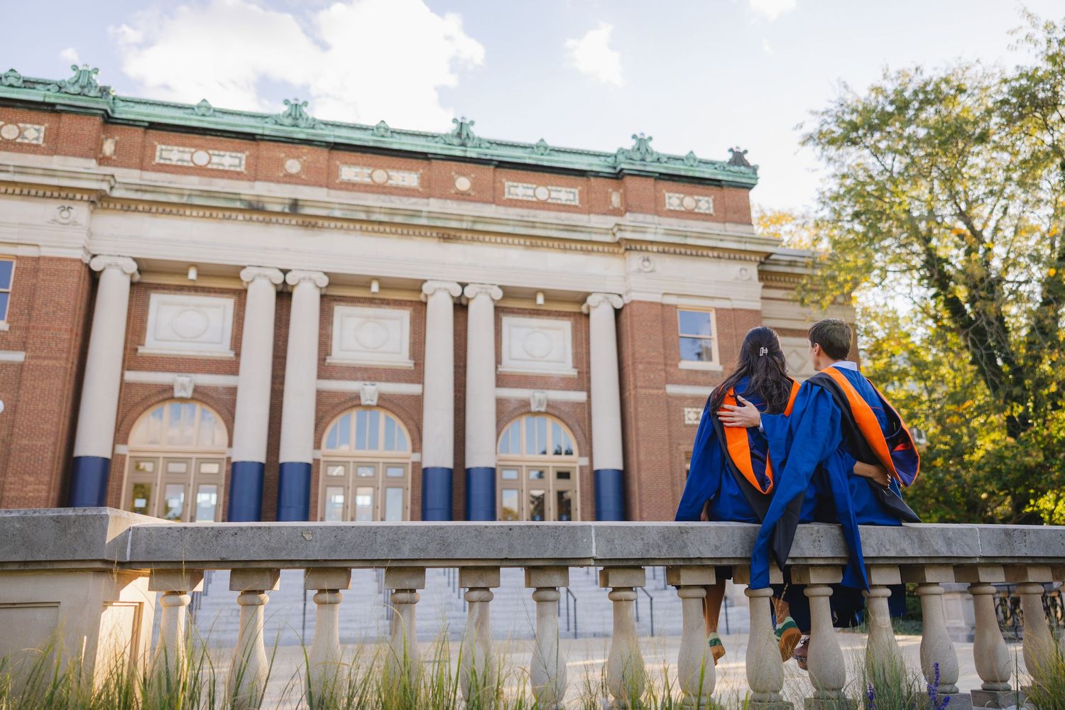 Two UIUC graduating students look up at Foellinger Auditorium