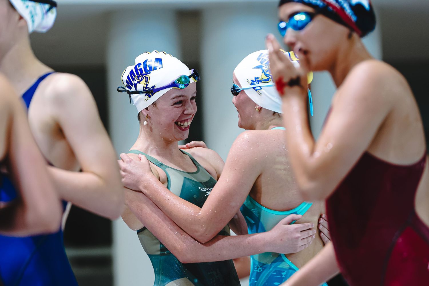 Competitive swimmer performing butterfly stroke in a swimming pool during a race competition.