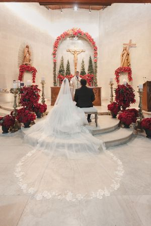 A church altar decorated with red poinsettias and floral arch for a wedding ceremony.