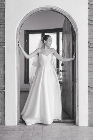 Artistic black and white series showing flowing wedding dress through arched doorways.