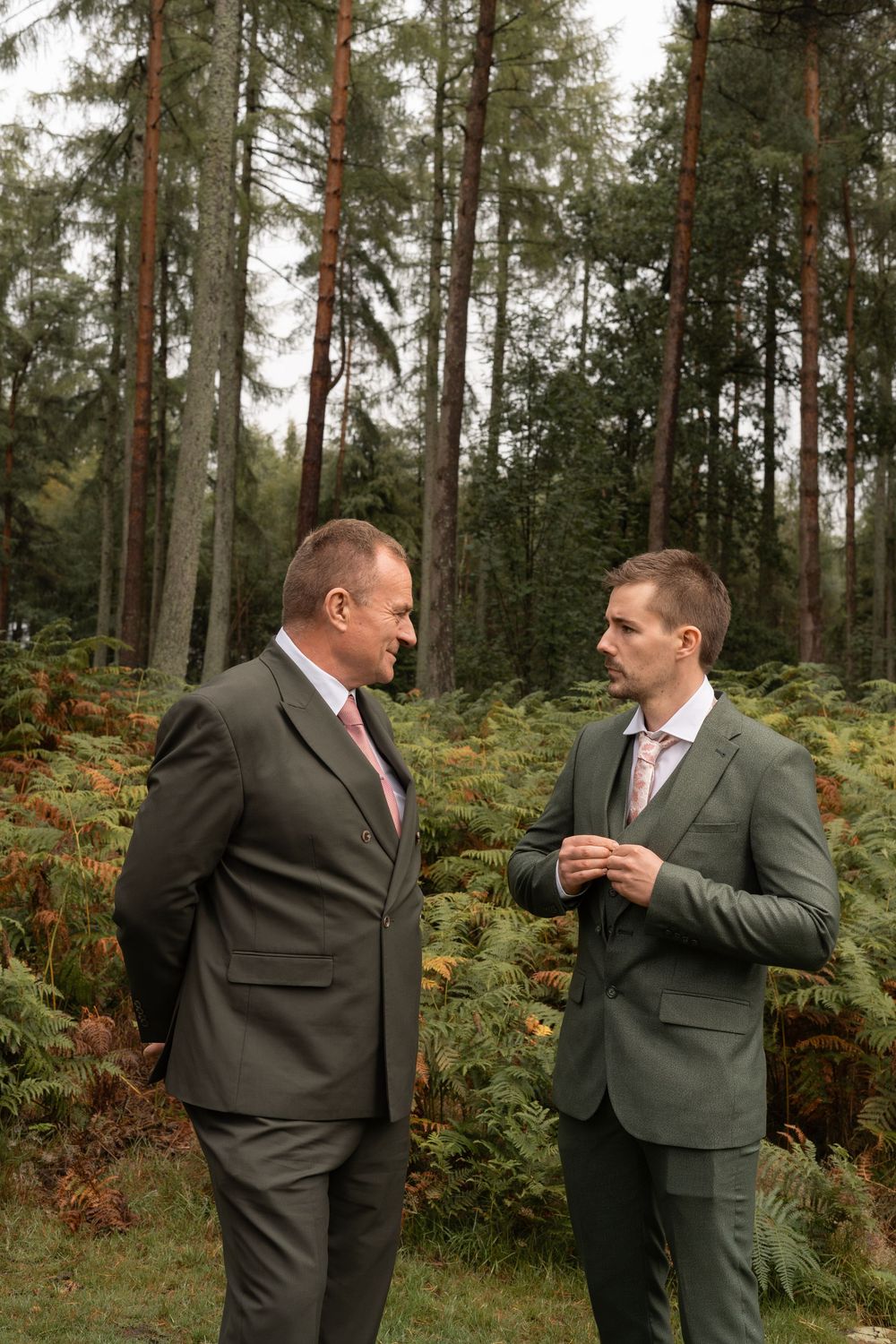 Four sequential photos show two men in suits having an animated conversation in a forest setting.