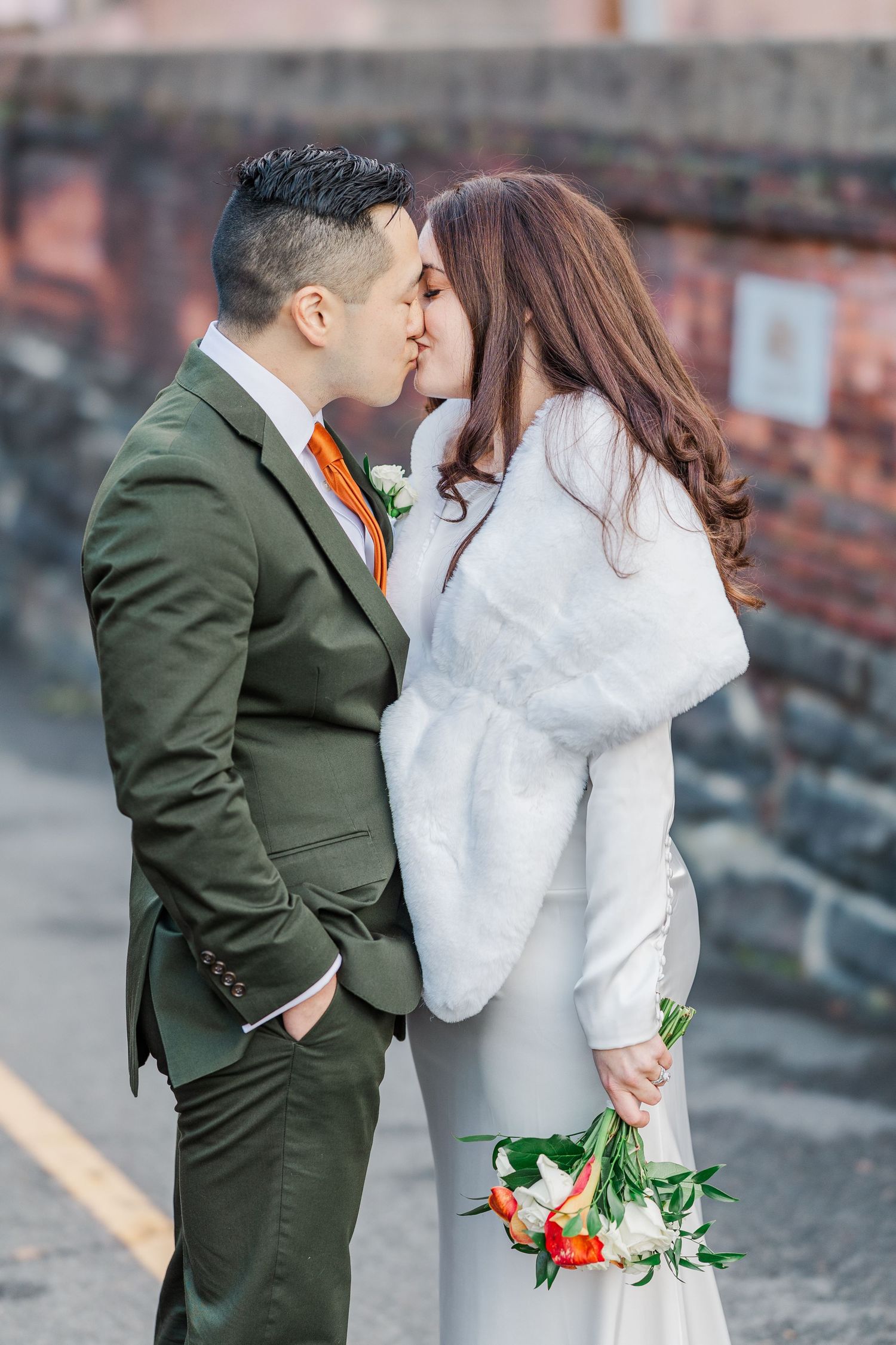 A couple in wedding attire share intimate moments while posing for photos, with the bride in white and groom in green.