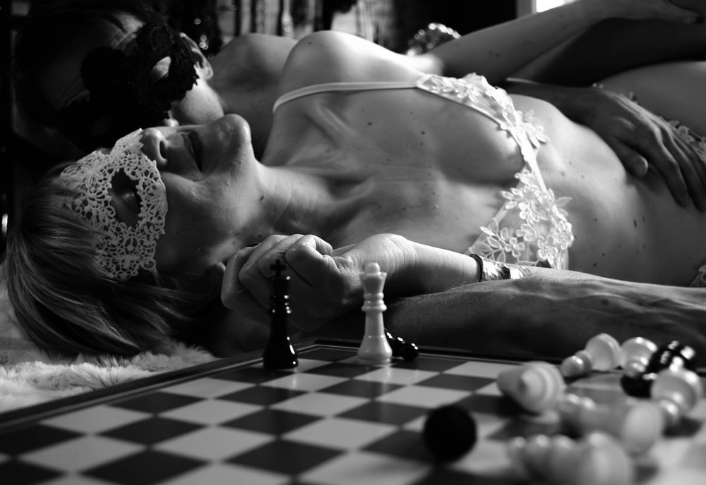 Black and white artistic boudoir photograph showing delicate lace details in dramatic lighting.