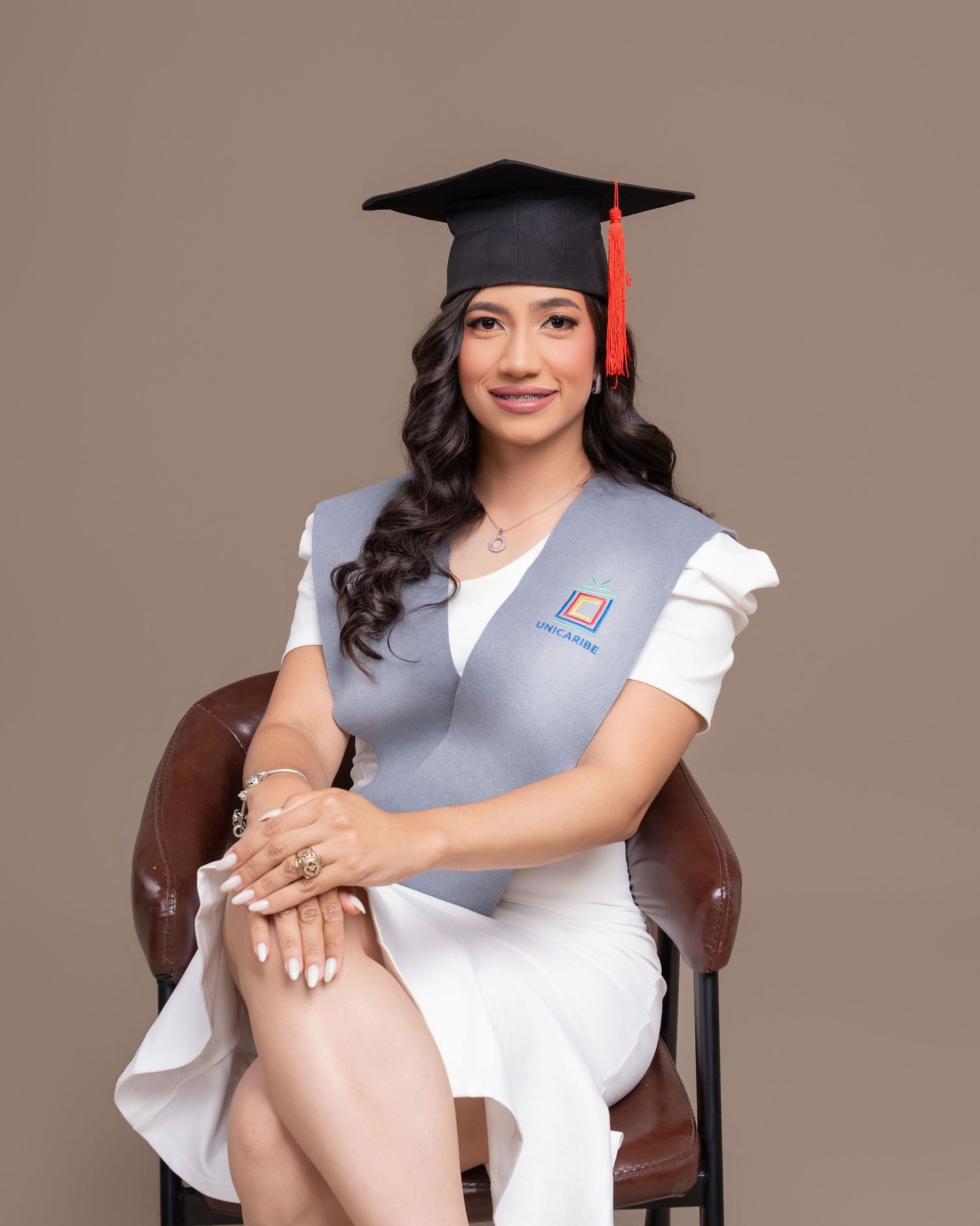 Graduate in black cap and gown holding a red diploma folder in various poses against a light background.