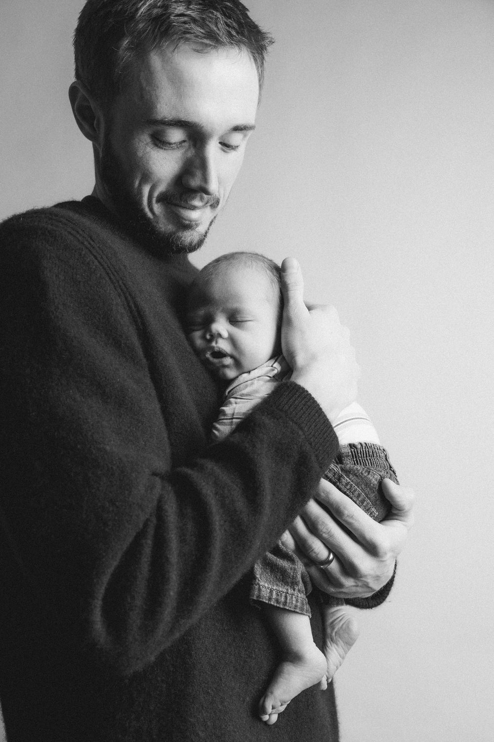 Black and white portraits capturing playful interactions between adult and infant.