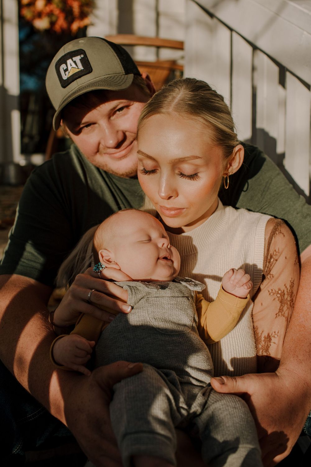 Tender family moment captured in warm autumn sunlight on a porch.