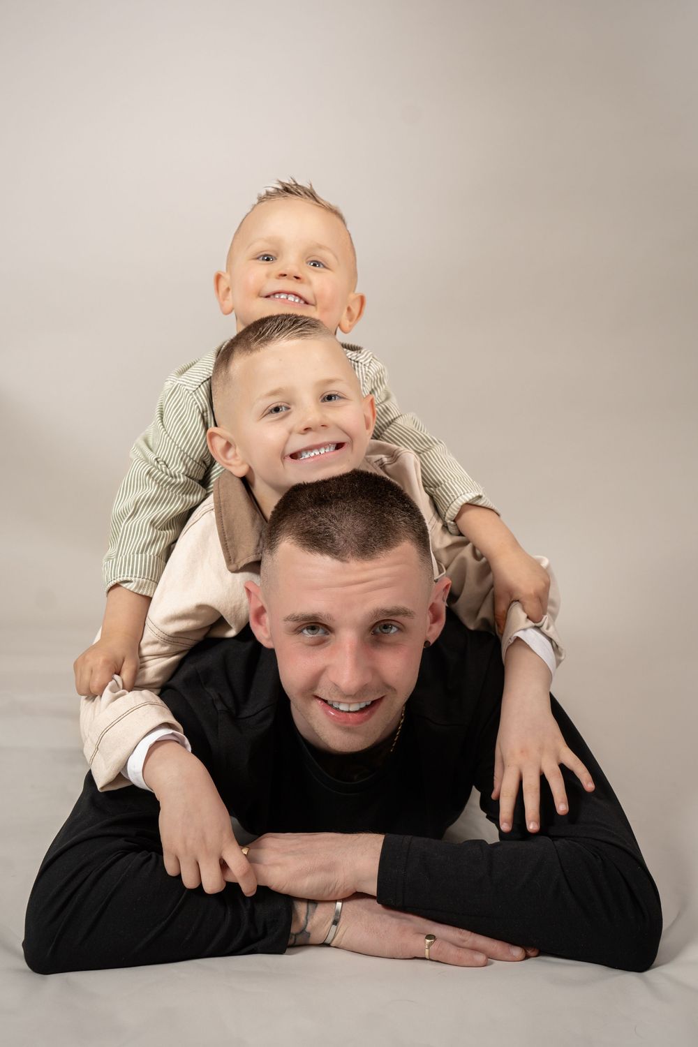 A playful sequence shows a parent and child laying on the floor together in matching light and dark clothing.