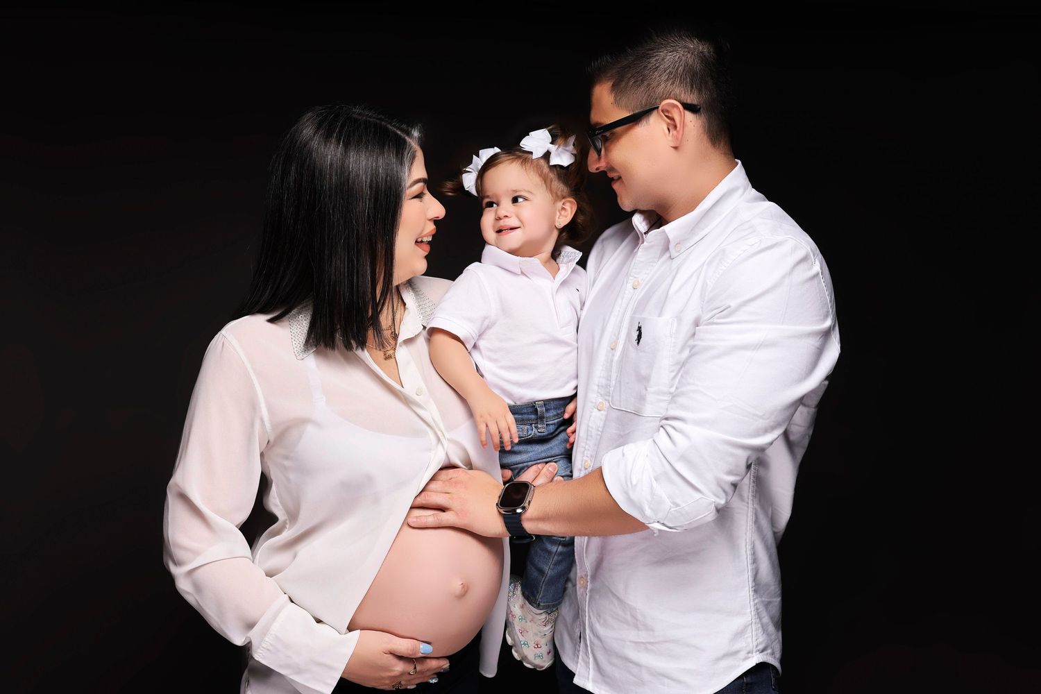 Emotional maternity photoshoot capturing intimate family moments in black and white.