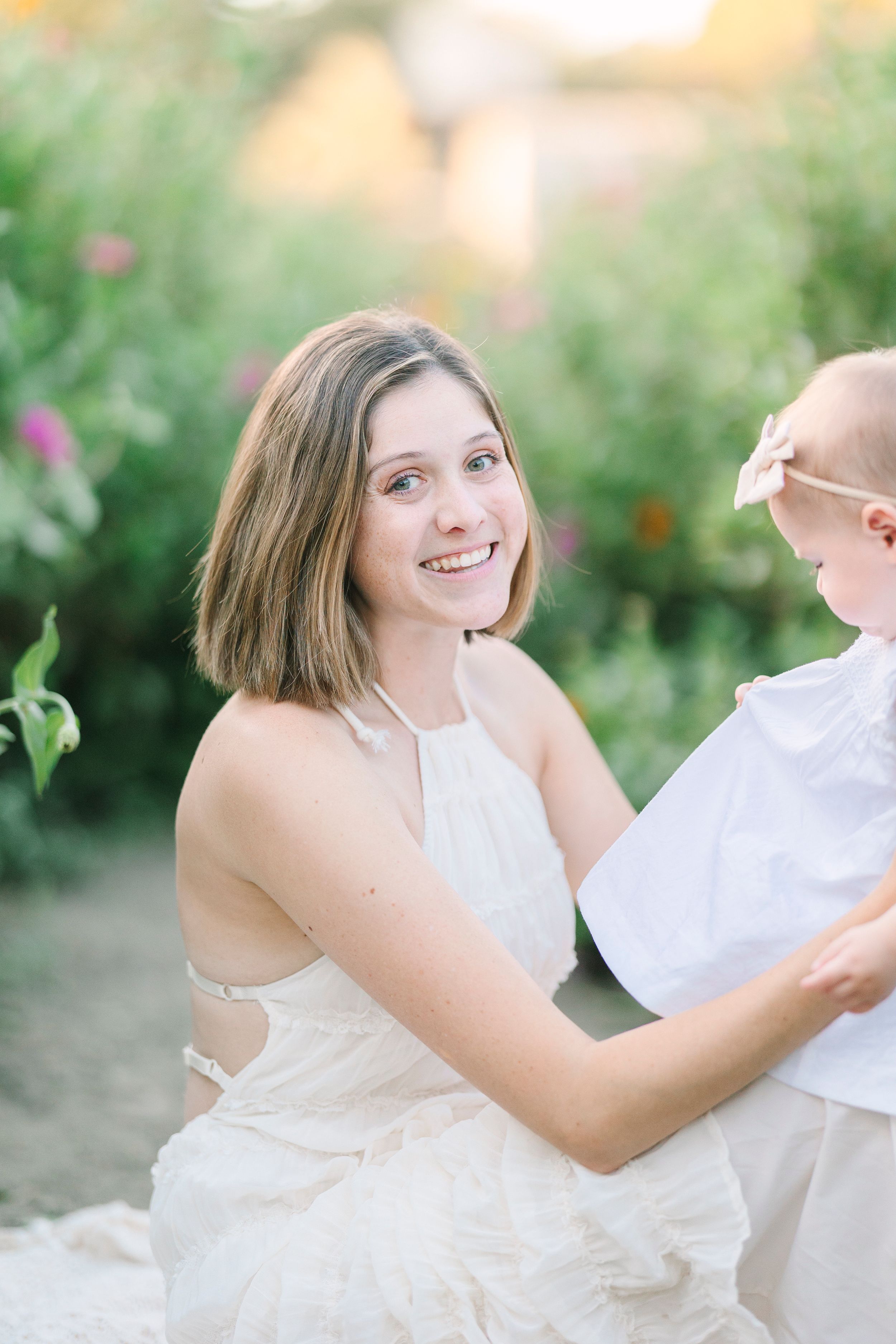 Joyful interactions in white dresses surrounded by greenery and natural light.