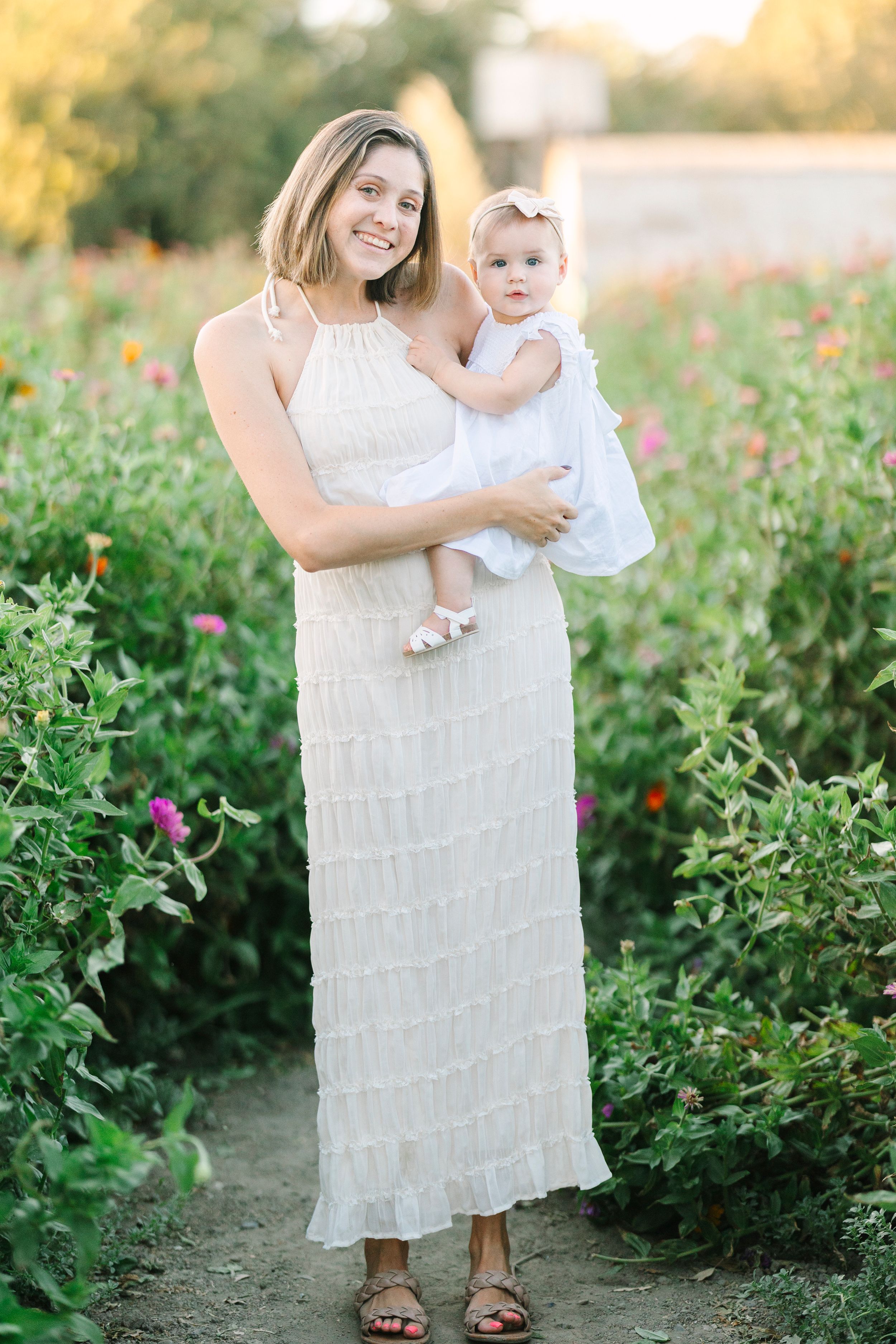 A white sundress moment captured in a blooming garden with colorful flowers.