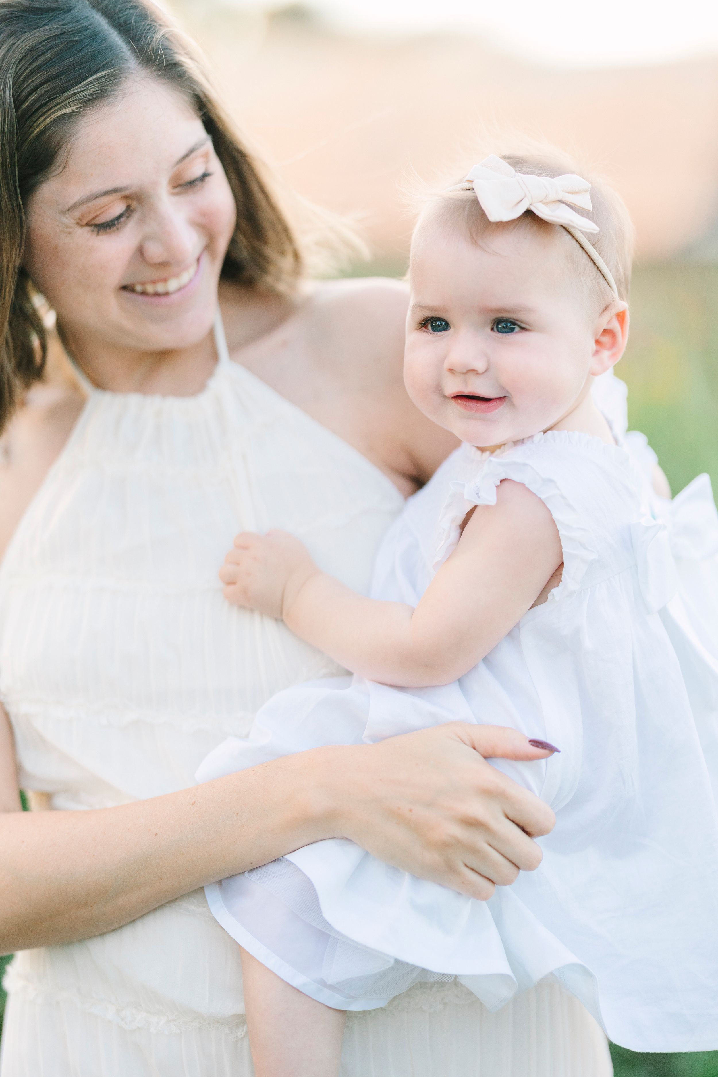 Sweet embraces in matching white outfits during an outdoor photo session.