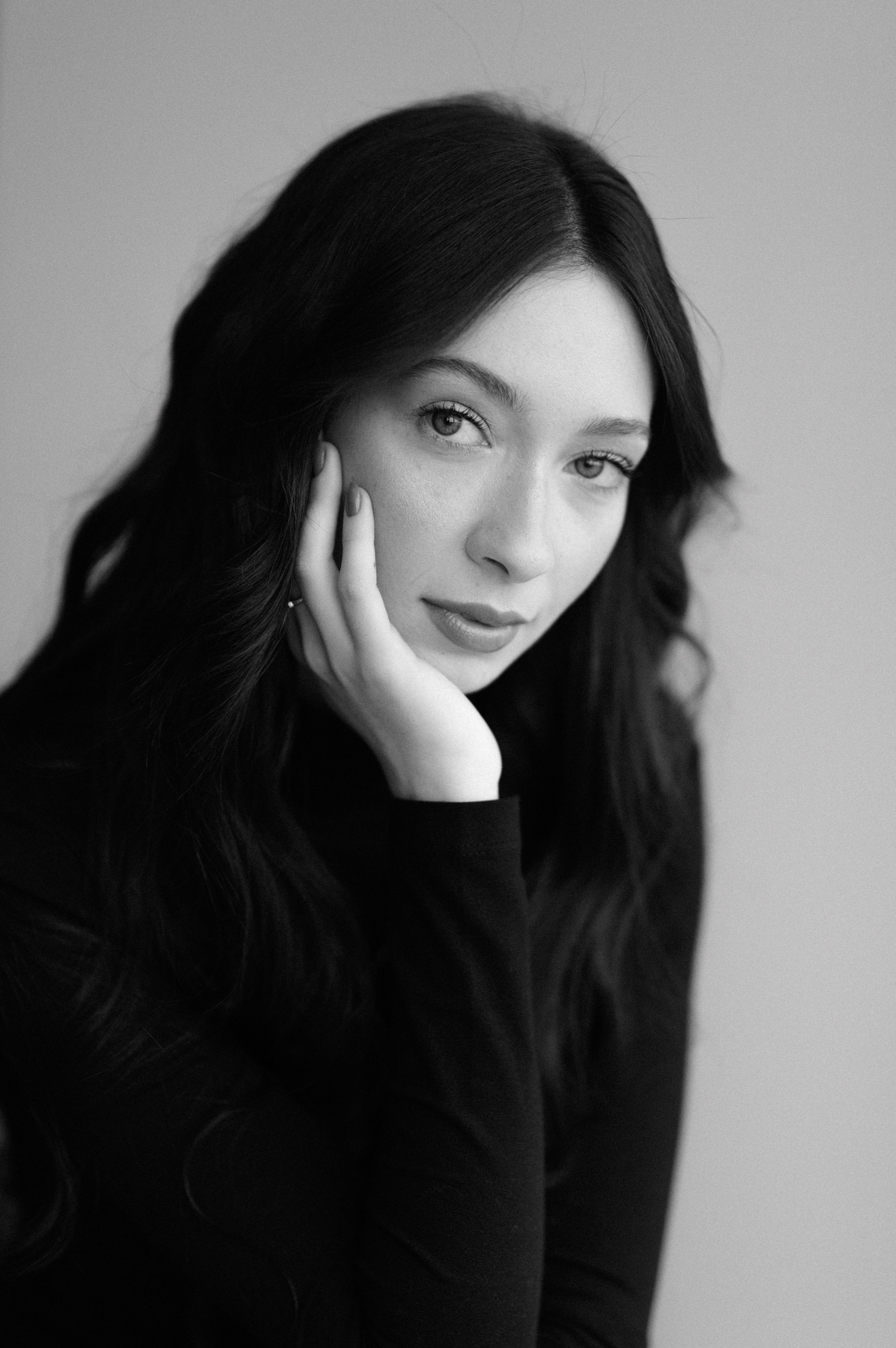 Artistic black and white portrait series showing contemplative poses against light background.