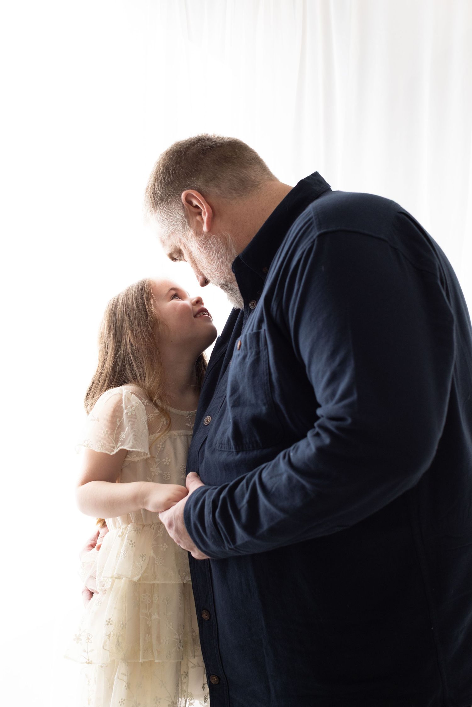 Three sequential photos show a romantic moment between a couple in formal attire against a white backdrop.