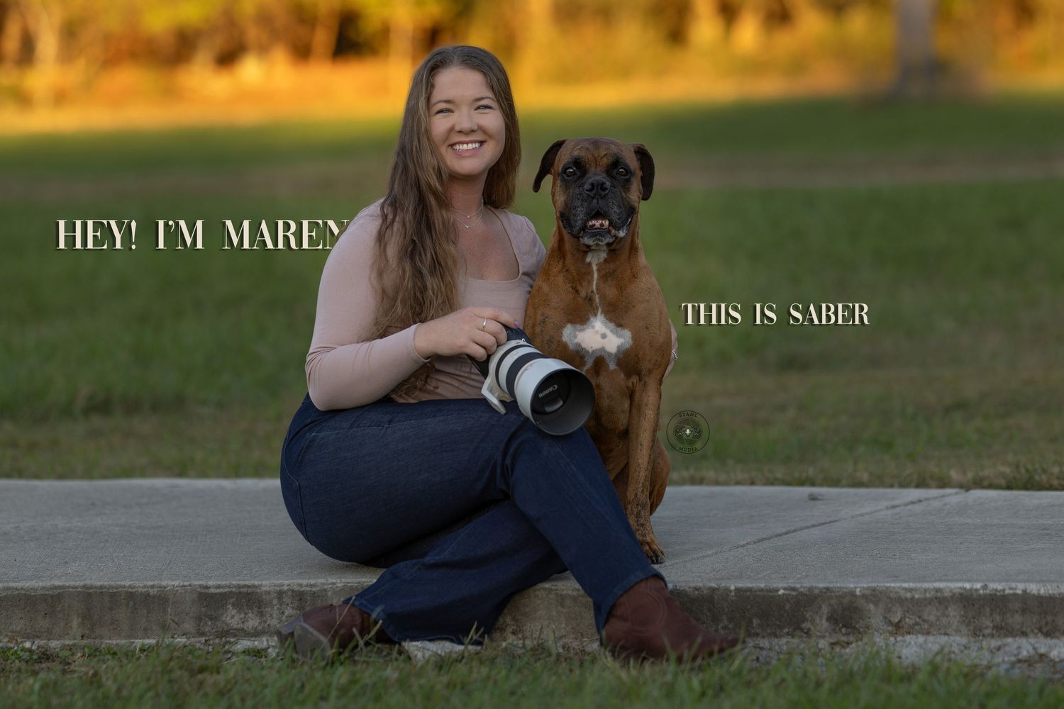A person in jeans sits outdoors with a brown dog on a sunny autumn day.